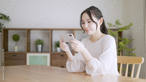 スマートフォンで動画を観る若い女性 photo