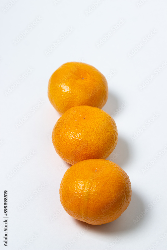 Tangerines on a white background. Citrus fruit. Three tangerines lie next to each other Tangerines on a white background. Citrus fruit. Three tangerines lie next to each other