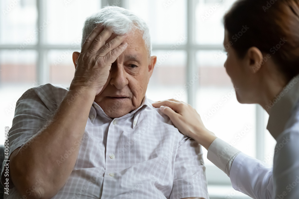 Φωτογραφία Attentive young lady physician interview senior patient on meeting listen to complaints make diagnosis