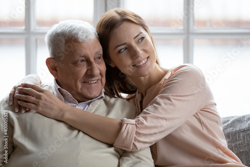 Affectionate grownup daughter embrace retired elderly dad sharing optimism positive emotions. Tender young woman hug beloved old grandfather dreaming together of good happy future long healthy life © fizkes