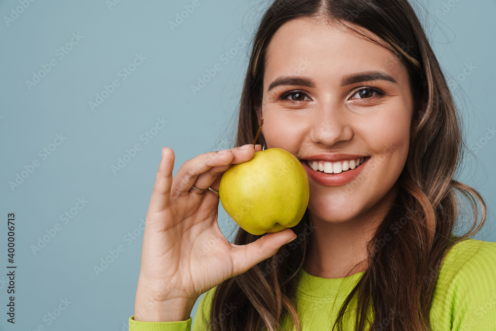Joyful beautiful cute girl smiling and showing apple Joyful beautiful cute girl smiling and showing apple