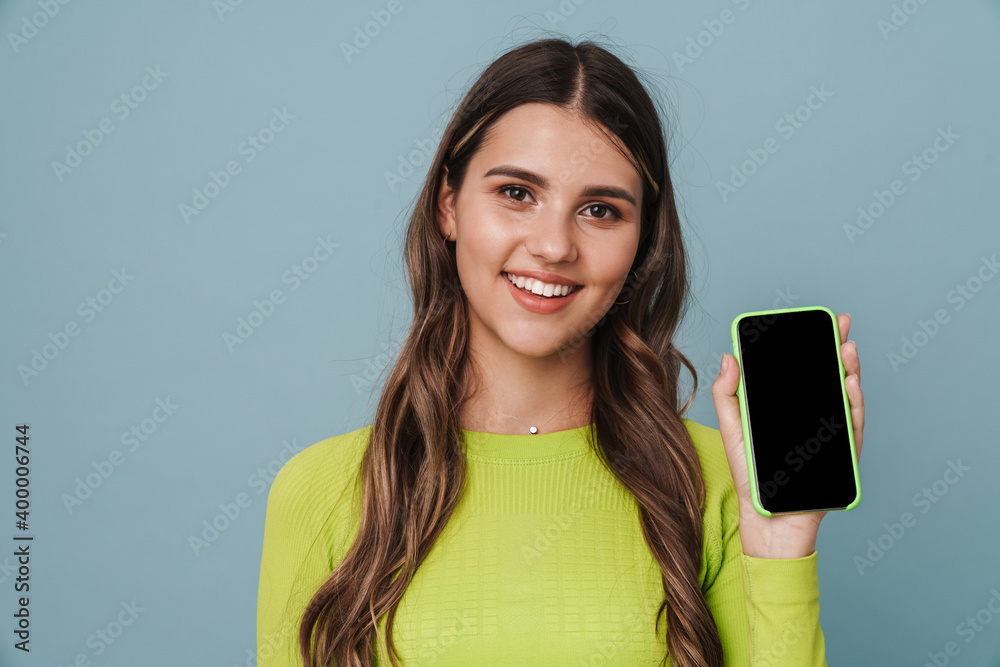 Fototapeta premium Happy beautiful cute girl smiling and showing mobile phone