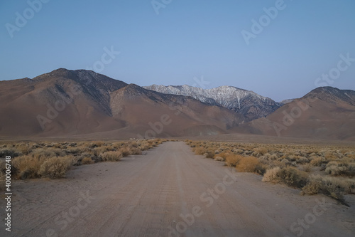 Dirt road toward snow covered Sierra Nevada photo