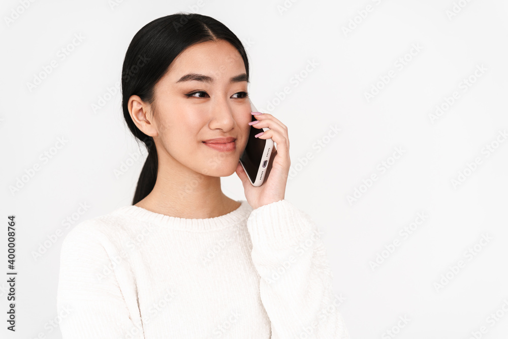 Asian pleased nice girl smiling while talking on mobile phone Asian pleased nice girl smiling while talking on mobile phone