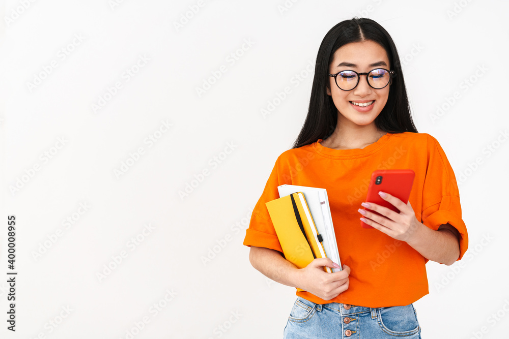 Asian happy student girl using smartphone and holding exercise books Asian happy student girl using smartphone and holding exercise books
