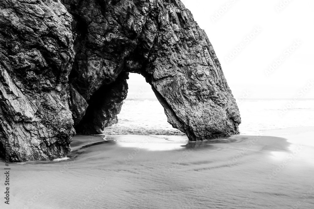 Beautiful stone natural arche. Rock formation in a beach with ocean in background.