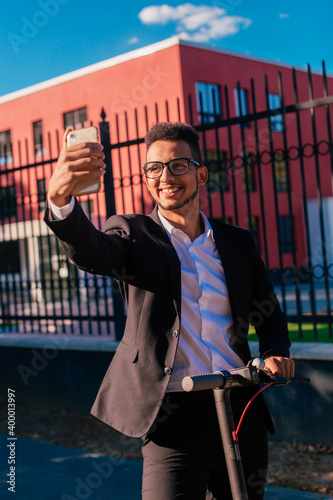Young beautiful african american man wearing glasses outside doing taking pictures with his phone