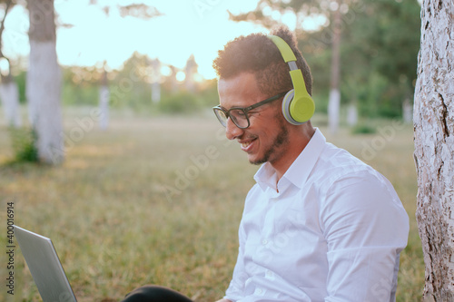 Lifestyle people man relax and listening music and work from home on the grass in nature park outdoors