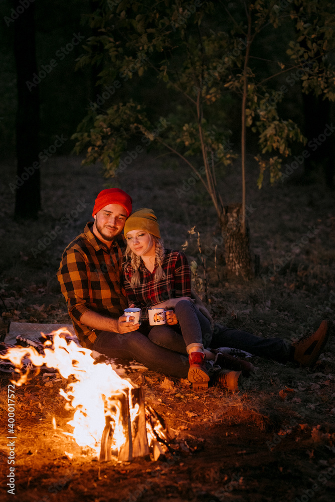 Young couple a guy and a girl in bright knitted hats stopped at a camping