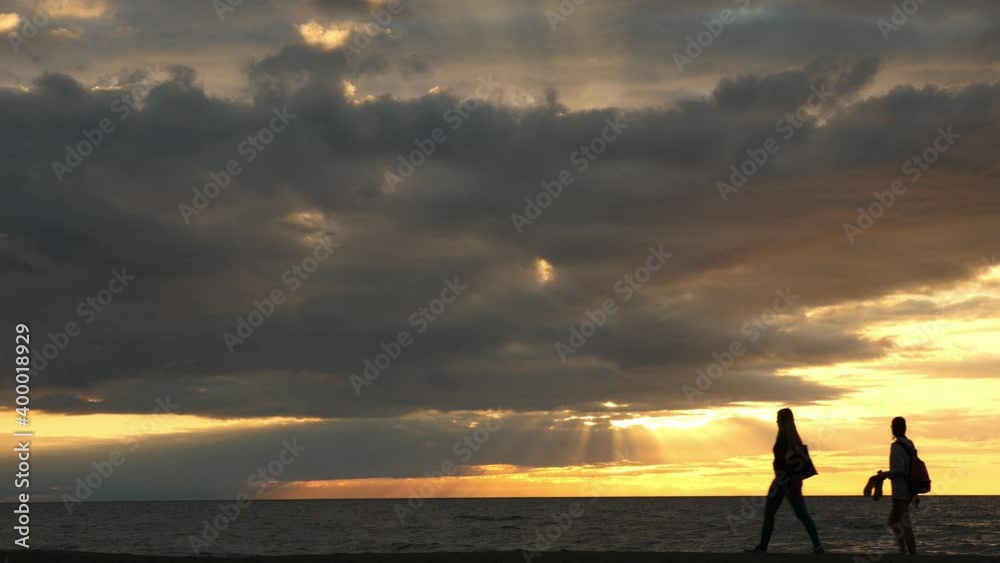 Evening on the sea shore, passing silhouettes of two people. Evening on the sea shore, passing silhouettes of two people.