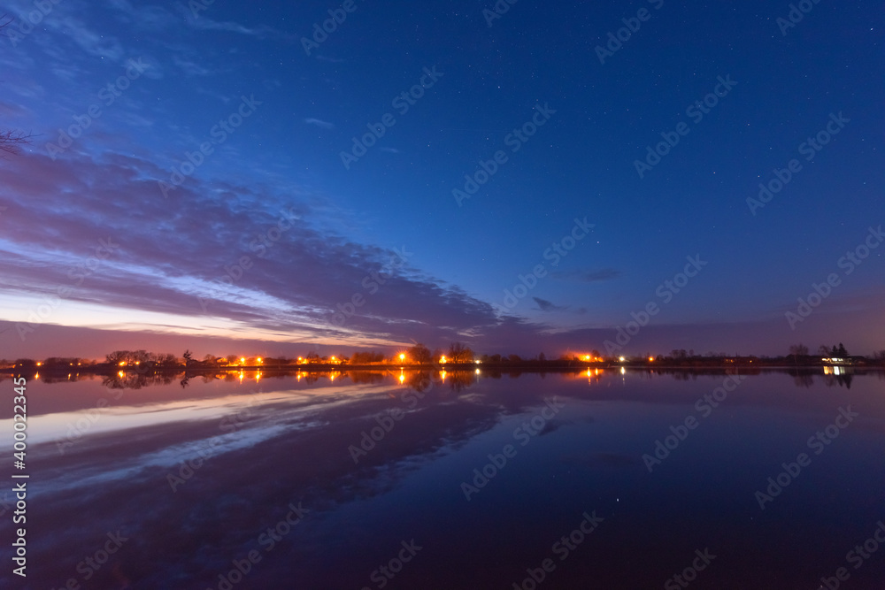 A magical starry night on the river bank with a large tree and a milky way in the sky and falling stars in the summer. A magical starry night on the river bank with a large tree and a milky way in the sky and falling stars in the summer.