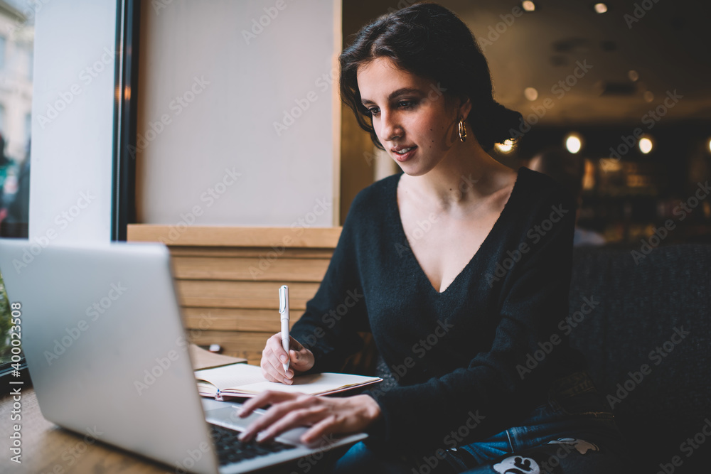 Concentrated female freelancer typing on laptop in cafe Concentrated female freelancer typing on laptop in cafe