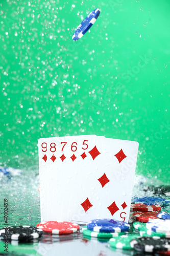 Straight combination under the water drops and falling poker chips against green background. Online gambling. Betting. Gambling addiction. Poker player.