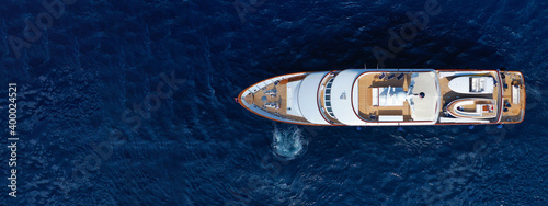 Aerial drone ultra wide photo of luxury yacht with wooden deck anchored in Mediterranean deep blue sea, Greece