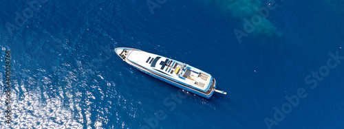 Aerial drone top down ultra wide photo of luxury yacht cruising in low speed in Mediterranean deep blue sea
