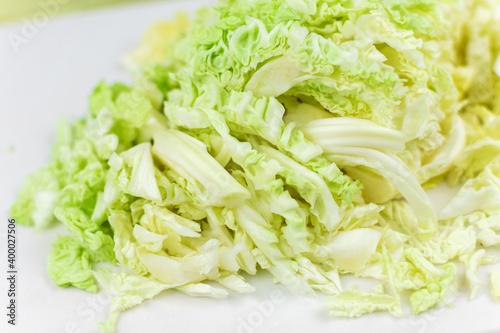 Shredded white cabbage on a white board.