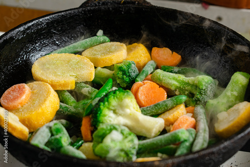 Frozen vegetables in a pan. Mix of different vegetables - carrots, green beans, cauliflower.