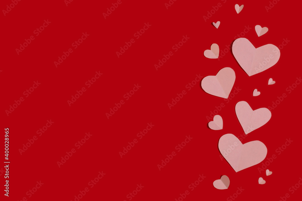 pink paper hearts on red background happy valentine's day greeting. Flat lay, copy space.