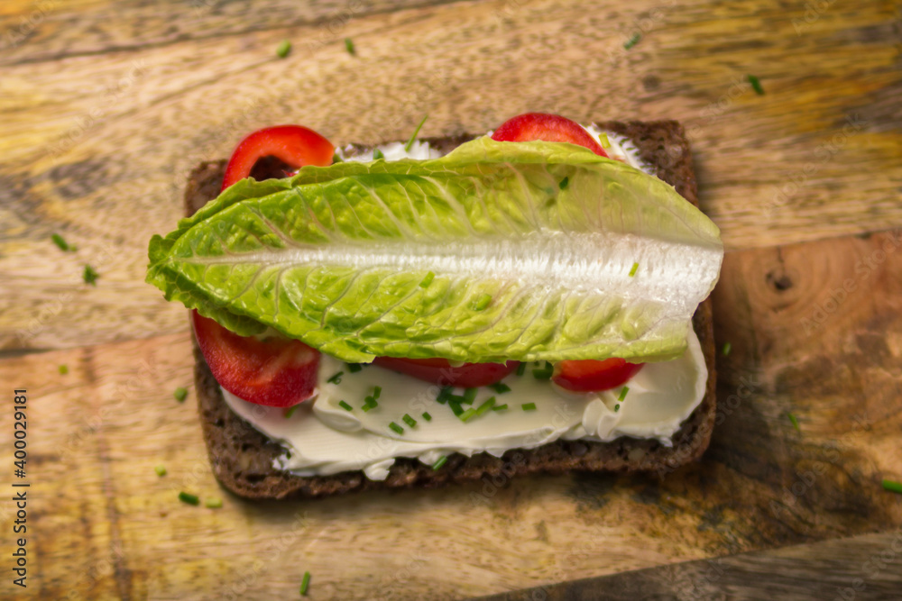Sonnenblumenbrot mit Frischkäse, Schnittlauch, Paprika und ein Salatblatt Sonnenblumenbrot mit Frischkäse, Schnittlauch, Paprika und ein Salatblatt