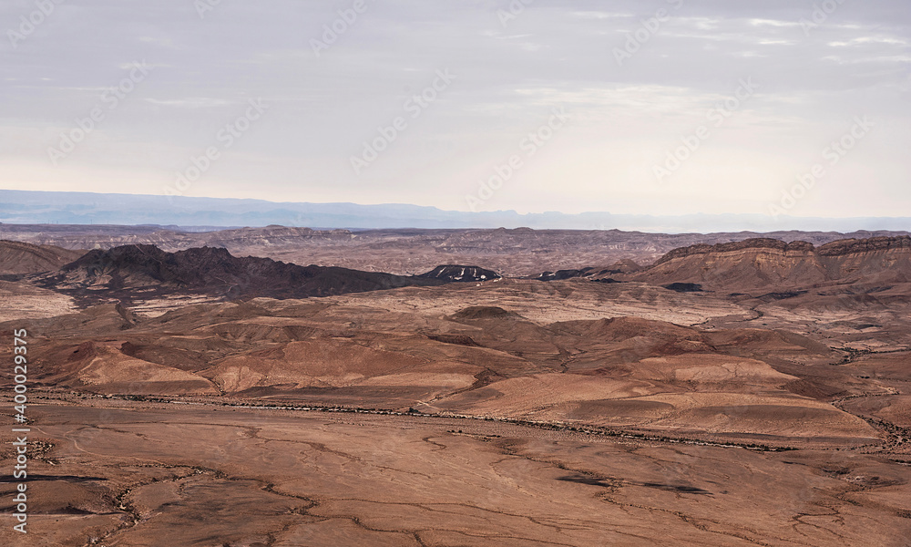 ramon's tooth from the overlook on the north rim of the makhtesh ramon crater in israel with the edom mountains of jordan and a grey sky in the background ramon's tooth from the overlook on the north rim of the makhtesh ramon crater in israel with the edom mountains of jordan and a grey sky in the background