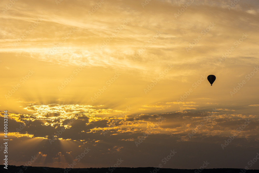 hot air balloon in the sky with orange sunrise clouds
