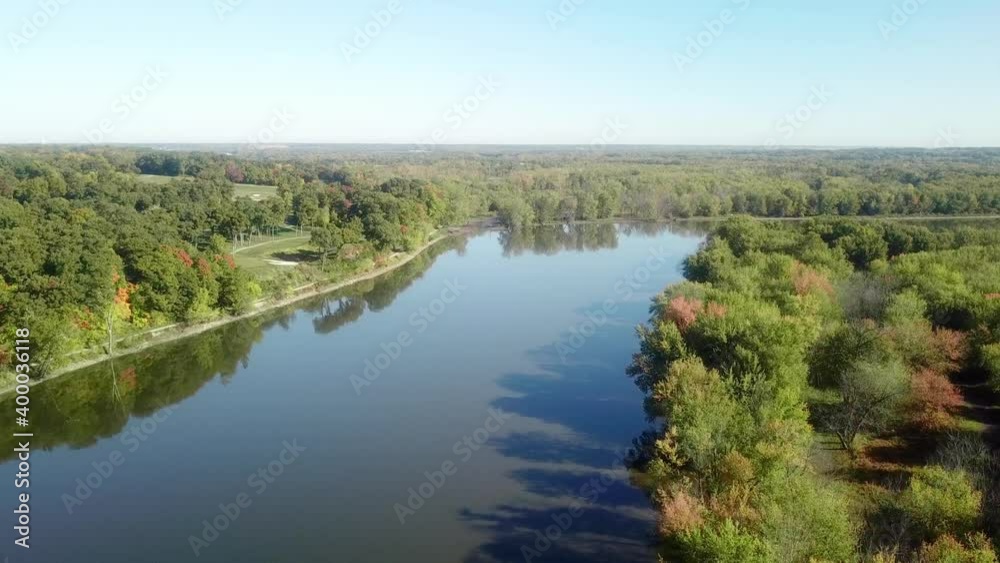 Low angle, slow drone view following the Iowa River water trail on a sunny late summer day near Iowa City Iowa; bike trail and golf course are visible Low angle, slow drone view following the Iowa River water trail on a sunny late summer day near Iowa City Iowa; bike trail and golf course are visible