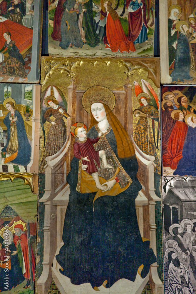 Vertical shot of a Gothic altarpiece with the Virgin Mary at its center in the Romanesque Santa María church in Artíes, Vall d’Aran, Lleida, Spain