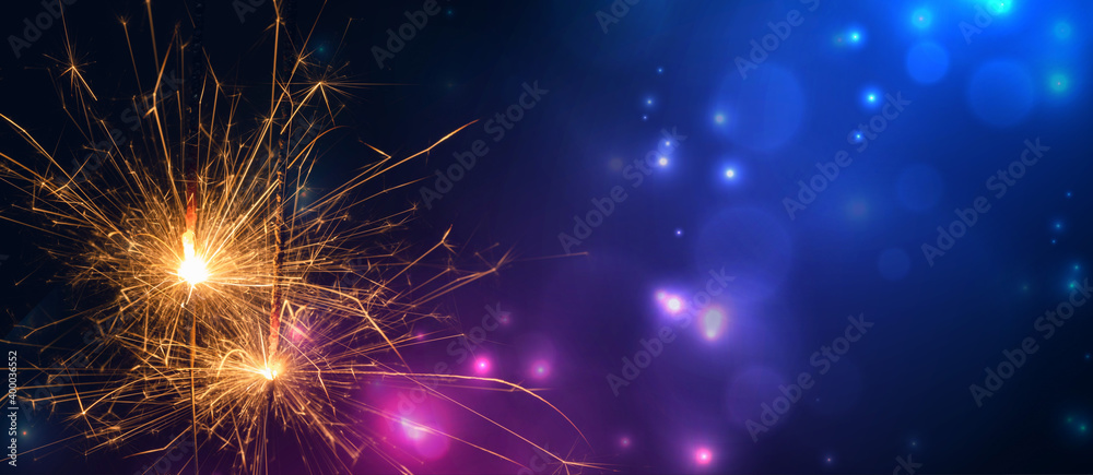 Burning sparklers on pink blue background Burning sparklers on pink blue background