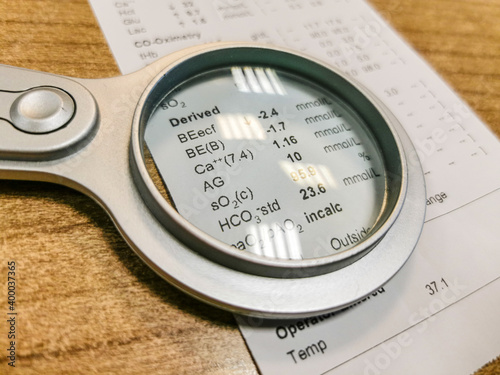 Results of arterial blood gas analysis examined under magnifying glass.