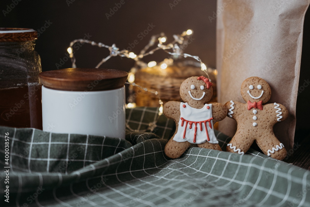 gingerbread cookies in the form of a pair of boy and girl on a green tablecloth on a wooden table. Valentine's Day. 
