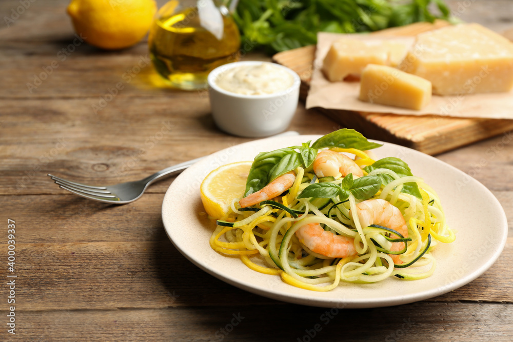 Delicious zucchini pasta with shrimps, lemon and basil on wooden table Delicious zucchini pasta with shrimps, lemon and basil on wooden table