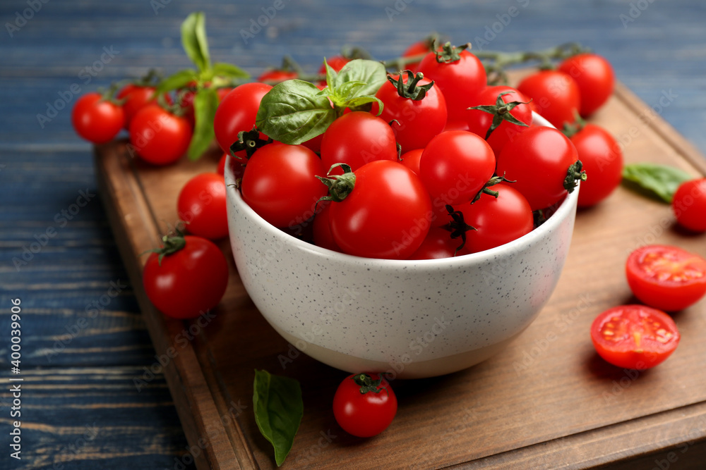 Fresh ripe cherry tomatoes and basil on blue wooden table, closeup Fresh ripe cherry tomatoes and basil on blue wooden table, closeup