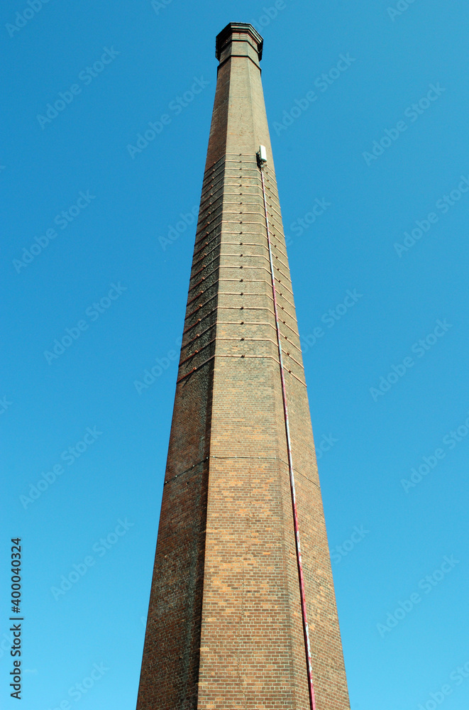 Tall Brick Industrial Chimney seen from  Below against Blue Sky 