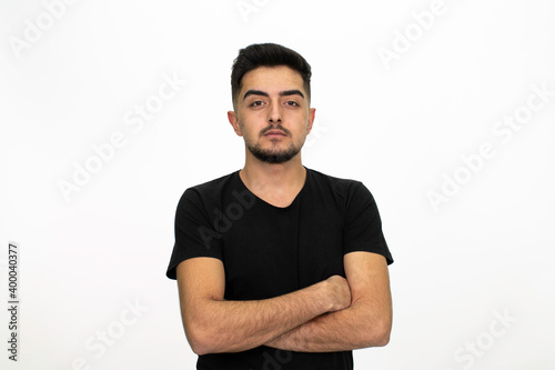 Young male model posing at studio. He is wearing a black shirt. Isolated image and white background. © Alaka Film