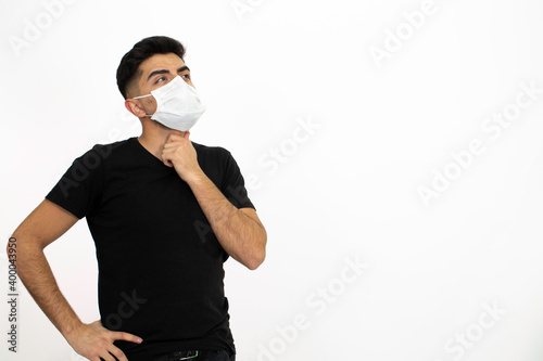 Young male model wearing a medical face mask. He is wearing a black shirt. White background and isolated image.