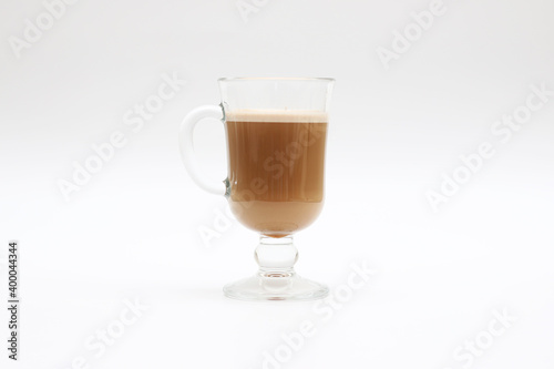 Hot cappuccino in a transparent glass cup on a white background
