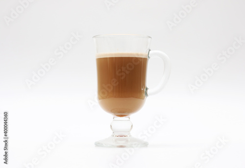 Hot coffee with milk in a transparent glass cup on a white background