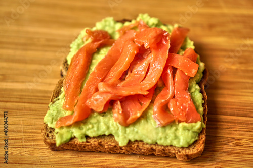 Homemade sandwich with red fish and avocado on grain bread. Delicious and healthy food. High quality photo