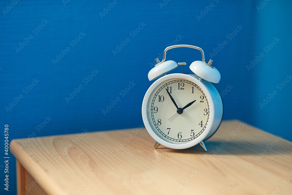 Alarm clock in a room, blue wall corner Alarm clock in a room, blue wall corner