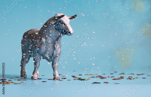 White Metal Bull is the Symbol of 2021 on blue background with snow