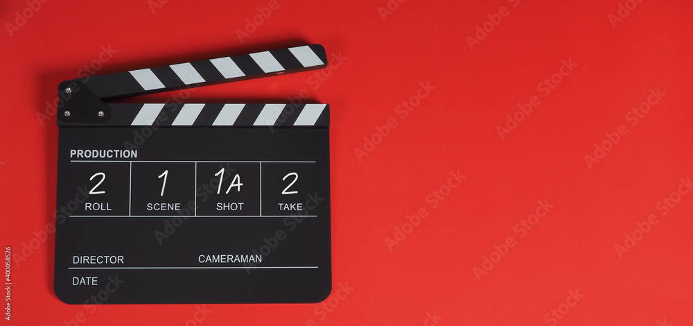 Clapper board or movie slate or clapperboard .It is use in film ,video and cinema industry on red background.