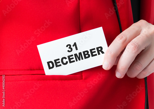 Text December 31 on the card in the hands of a businessman, a close-up of the jacket.