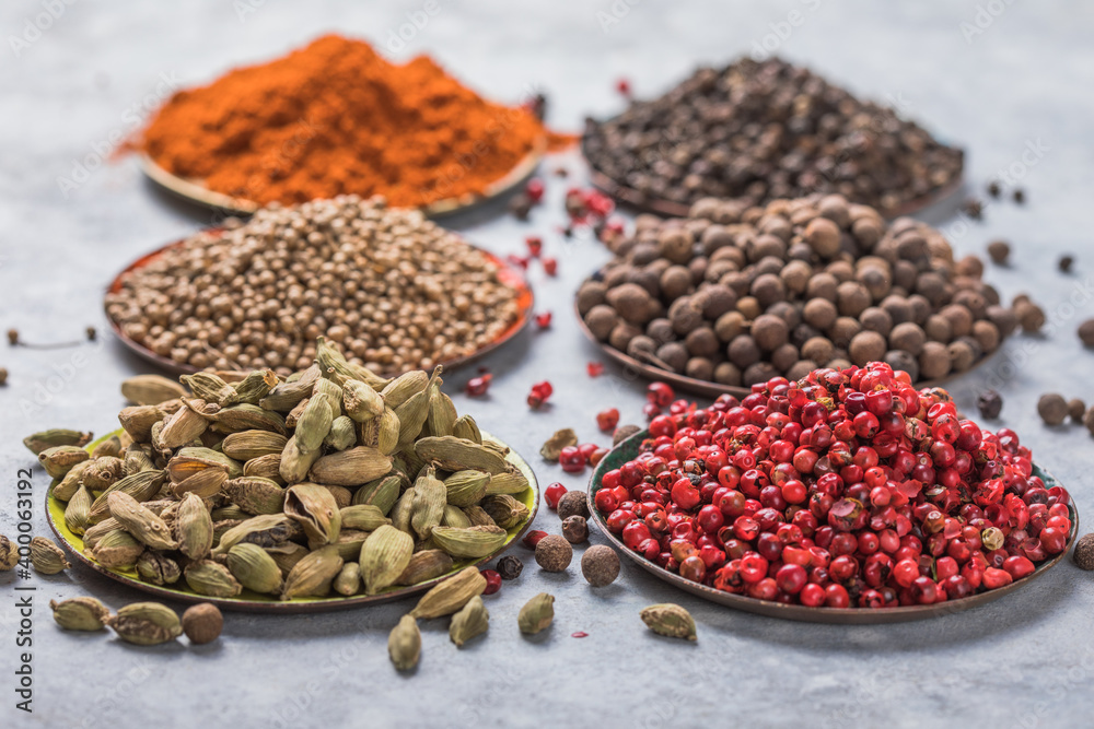 mix of aromatic coriander, black, red peppercorn, paprika in white cups on gray concrete background . Healthy food.Bowls with various spices on white background mix of aromatic coriander, black, red peppercorn, paprika in white cups on gray concrete background . Healthy food.Bowls with various spices on white background