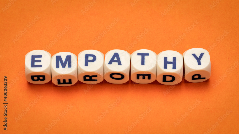 Obraz premium empathy word abstract in dice letters against handmade orange paper, the ability to understand and share the feelings of another