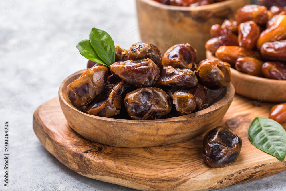Dates or dattes palm fruit in wooden bowl is snack healthy.Creative layout made of dried dates. Flat lay. Food concept. Fruits dates. Dates Palm fruit isolated on white. Dried fruits. Healthy diet. Dates or dattes palm fruit in wooden bowl is snack healthy.Creative layout made of dried dates. Flat lay. Food concept. Fruits dates. Dates Palm fruit isolated on white. Dried fruits. Healthy diet.