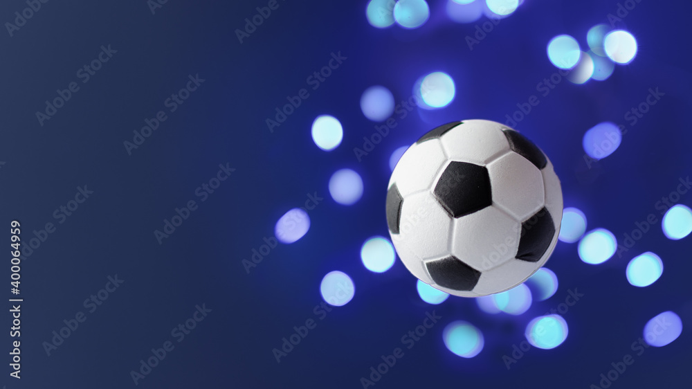 Naklejka premium Traditional soccer ball flying over blue background.