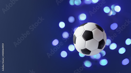 Traditional soccer ball flying over blue background.