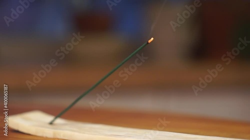 Incense stick with smoke on a wooden table in the room. Relaxation, rest and tranquility background.