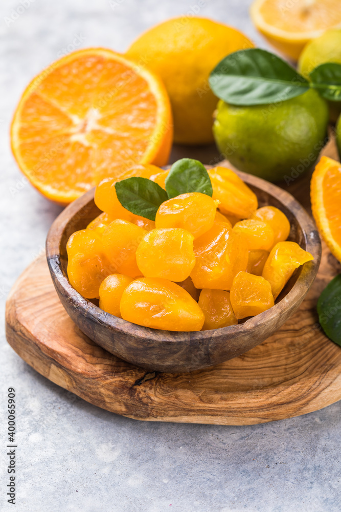Сandied fruit, dried kumquat  with orange flavor in bowl on stone table background.