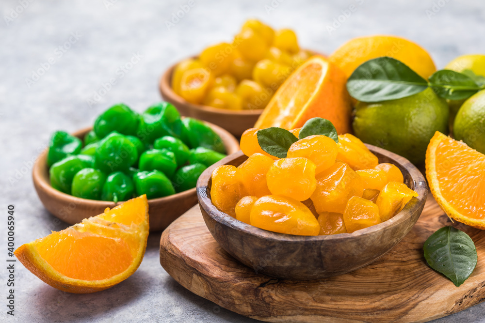 Variety Сandied fruit, dried kumquat  with orange, lime, lemon  flavor in bowl on stone table background.